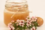 Flores de manuka junto a tarro con miel