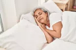 Dormir bien ayuda a envejecer con salud Mujer de mediana edad durmiendo plácidamente