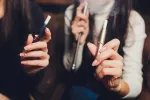Sanidad regula bolsas de nicotina y vapeadores y restringe los aromatizantes Grupo de personas usando dispositivos y vapeadores electrónicos
