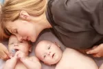 Dar a luz a dos bebés aumenta el riesgo de enfermedad cardíaca en el primer año tras el parto Mujer junto a sus dos bebés de pocos meses