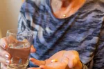 Ciertos antidepresivos podrían acelerar el deterioro cognitivo en pacientes con demencia Mujer mayor sostiene una pastilla y un vaso de agua
