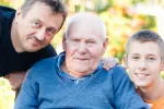 Los hijos de hombres con alzhéimer podrían tener más riesgo de desarrollar la enfermedad Padre e hijo posan a los lados del abuelo con alzhéimer