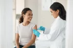 La vacuna de Pfizer contra el COVID puede ayudar a controlar o reducir la inflamación innata Una doctora administra la vacuna contra el COVID a una joven sonriente