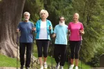 Dos mujeres y dos hombres mayores realizan una caminata al aire libre Grupo de personas mayores practica marcha nórdica en un bosque