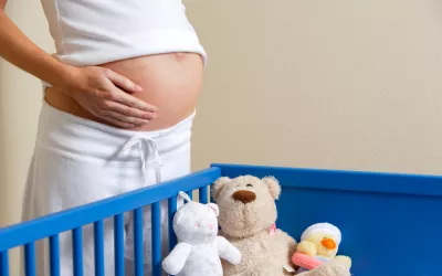 Síndrome del nido: poniendo todo a punto para el bebé Embarazada preparando la cuna de su bebé