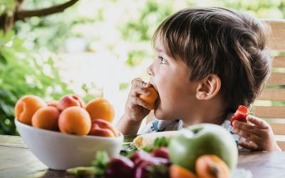 Niño comiendo fruta al aire libre